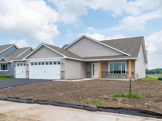 view of front of property featuring a garage, stone siding, aphalt driveway, and a shingled roof