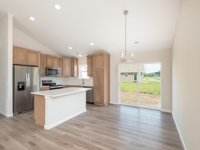 kitchen featuring a kitchen island, vaulted ceiling, stainless steel appliances, light countertops, and a sink