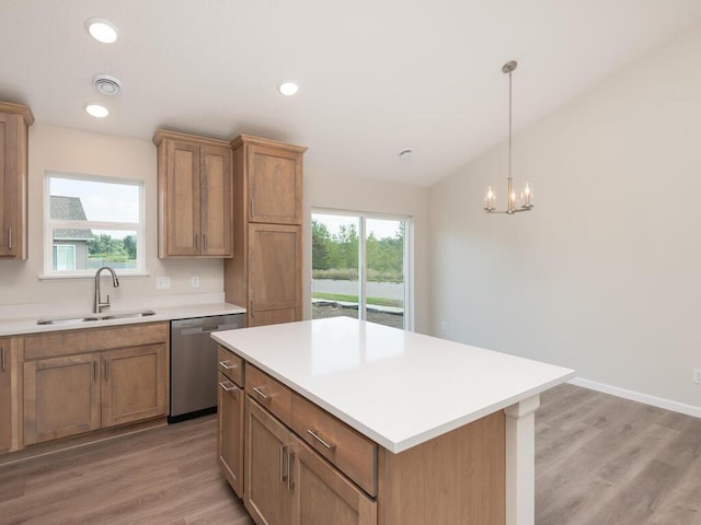 kitchen featuring a wealth of natural light, light countertops, dishwasher, and a sink