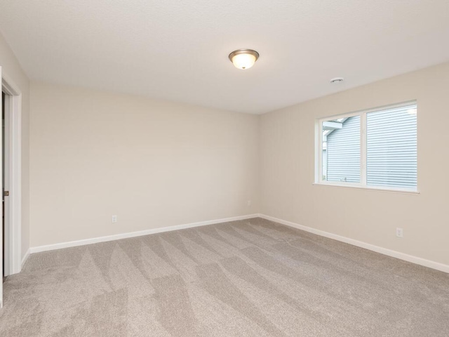 carpeted spare room with baseboards