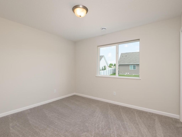 carpeted spare room with baseboards