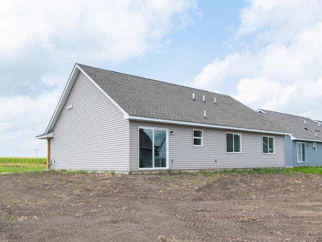 back of property with a shingled roof