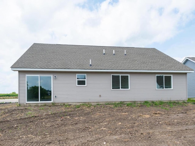 back of house with a shingled roof