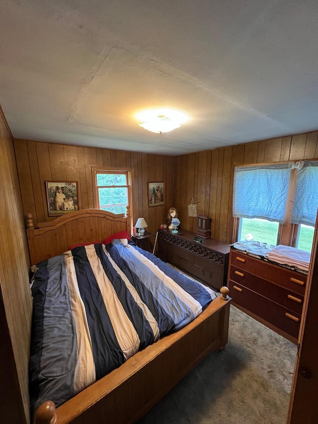 bedroom with carpet floors and wooden walls