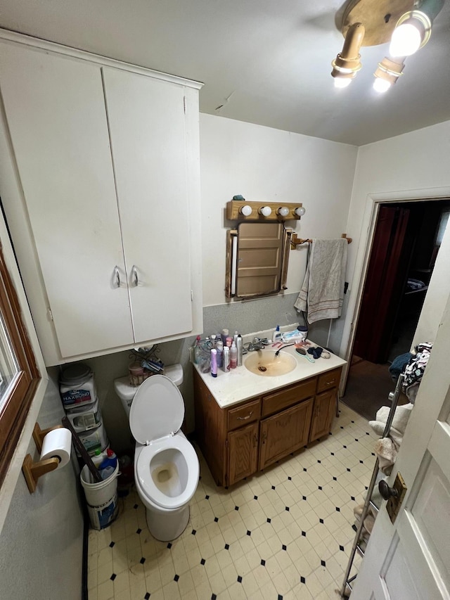 bathroom with toilet, tile patterned floors, and vanity