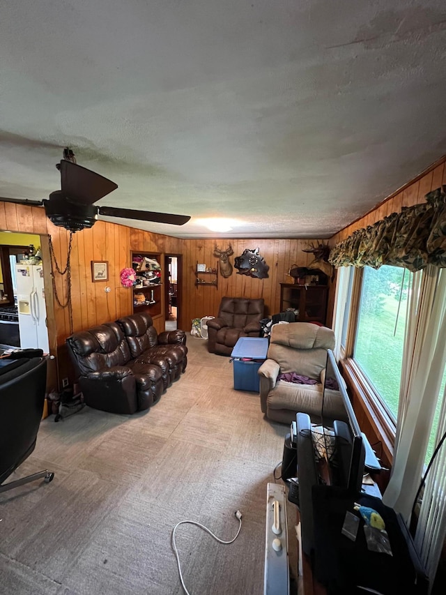 living area featuring carpet floors and wooden walls