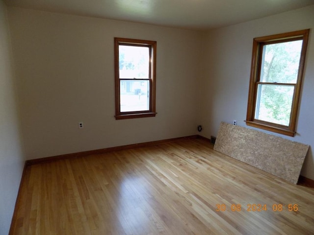 empty room with light wood finished floors and baseboards