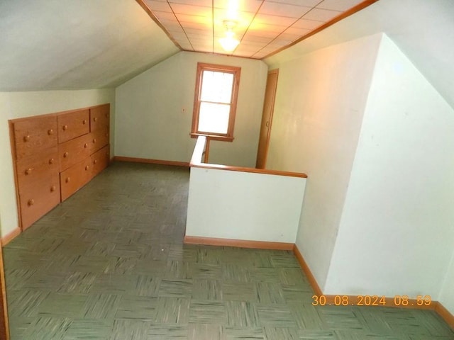 bonus room featuring baseboards and lofted ceiling