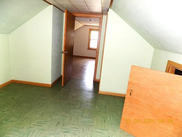 additional living space featuring vaulted ceiling and baseboards