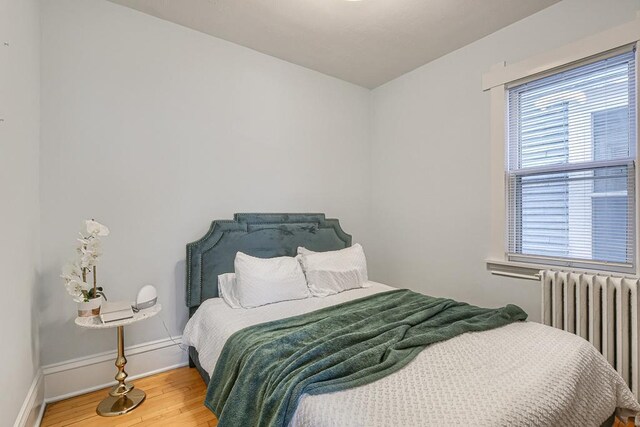 bedroom featuring light wood-type flooring and radiator