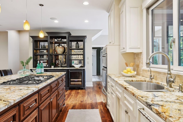 kitchen featuring sink, dark hardwood / wood-style flooring, pendant lighting, wine cooler, and appliances with stainless steel finishes