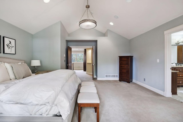 carpeted bedroom featuring connected bathroom and vaulted ceiling