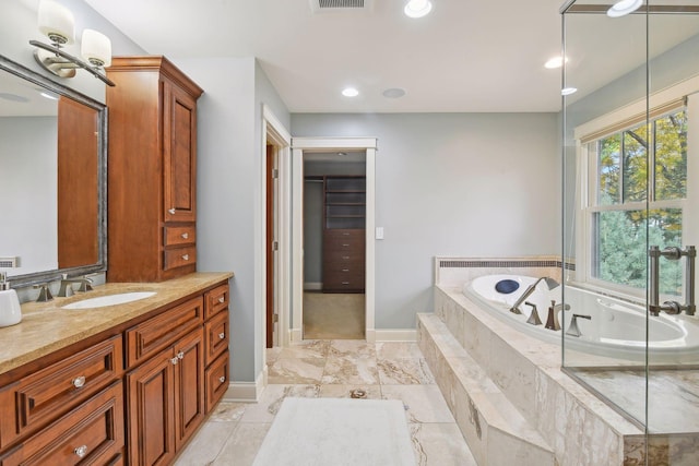 bathroom with vanity and tiled tub