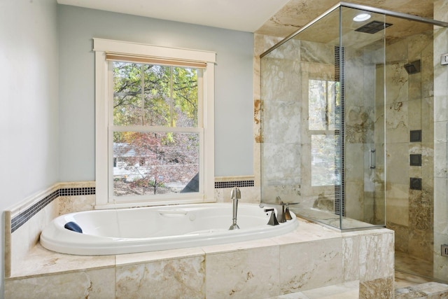 bathroom featuring shower with separate bathtub