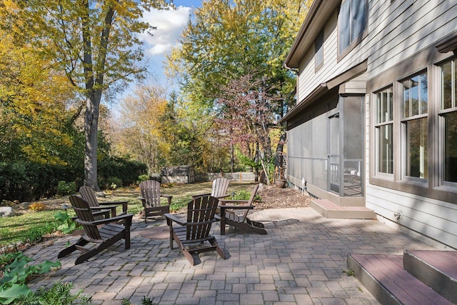 view of patio with an outdoor fire pit and a sunroom