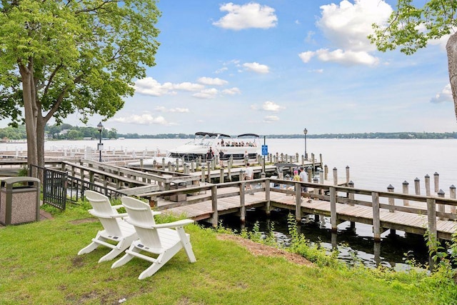 dock area with a lawn and a water view