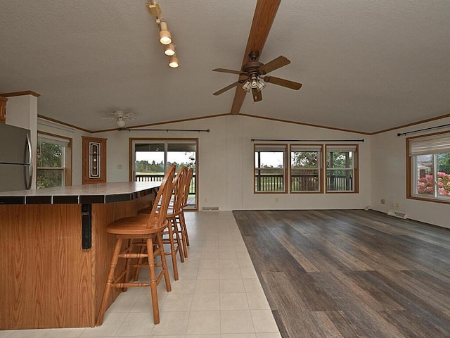 27602 County Road 51, Bovey, MN 55709 - interior space with ceiling fan, a textured ceiling, a breakfast bar, lofted ceiling, and open floor plan