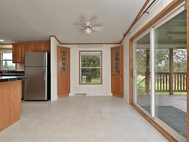 27602 County Road 51, Bovey, MN 55709 - kitchen featuring ornamental molding, freestanding refrigerator, a ceiling fan, visible vents, and brown cabinets