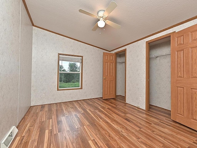 27602 County Road 51, Bovey, MN 55709 - unfurnished bedroom with a textured ceiling, a ceiling fan, ornamental molding, visible vents, and wood finished floors