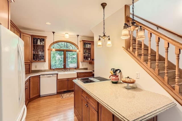 kitchen featuring light hardwood / wood-style flooring, pendant lighting, white appliances, and sink