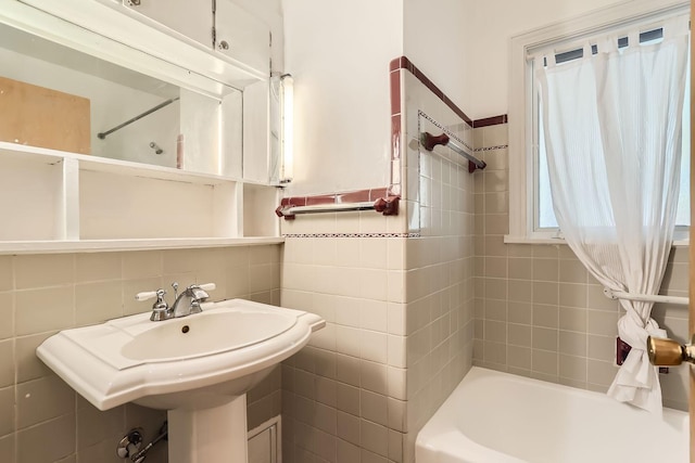 bathroom with tiled shower / bath and tile walls