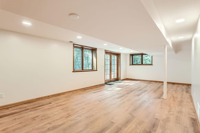 basement featuring light wood-type flooring and french doors