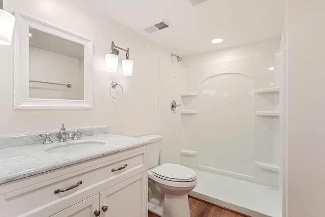 bathroom featuring vanity, toilet, a shower, and wood-type flooring