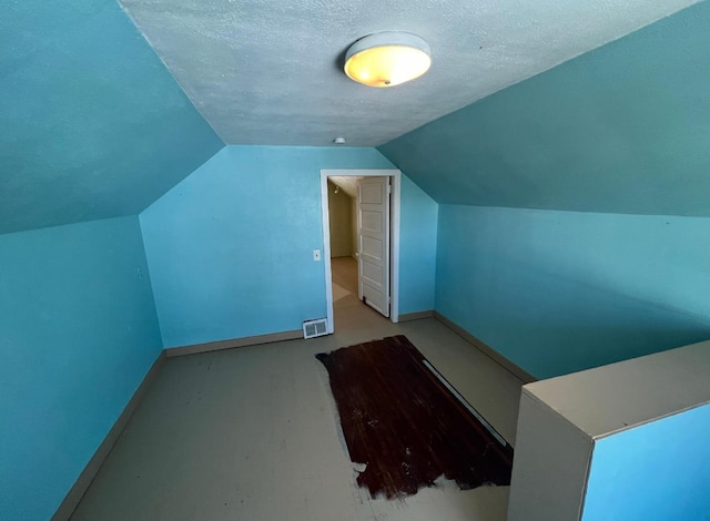 bonus room featuring lofted ceiling and a textured ceiling