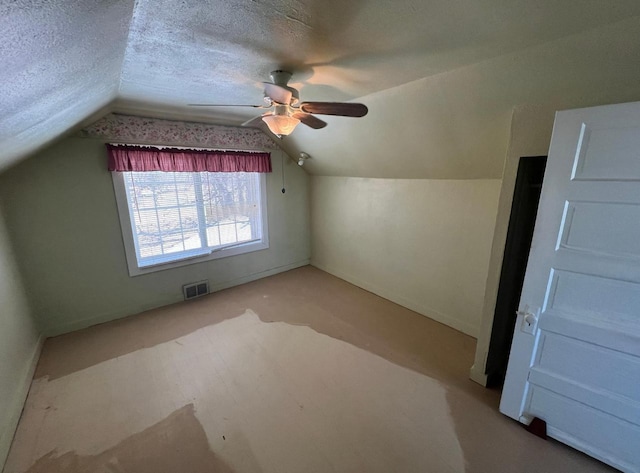 bonus room featuring a textured ceiling, vaulted ceiling, and ceiling fan