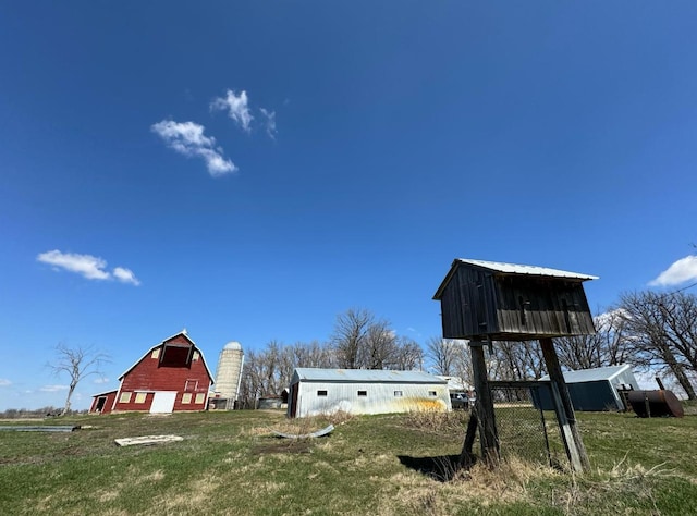 view of yard featuring driveway, an outdoor structure, a detached garage, and a barn