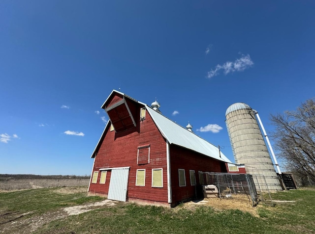 exterior space with a detached garage, a lawn, metal roof, a barn, and an outdoor structure