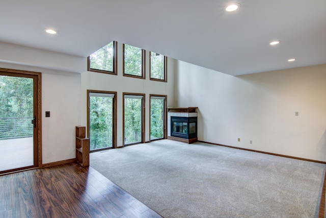 unfurnished living room featuring a multi sided fireplace and hardwood / wood-style floors