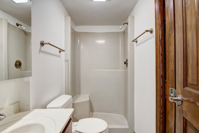 bathroom with a textured ceiling, a shower, vanity, and toilet