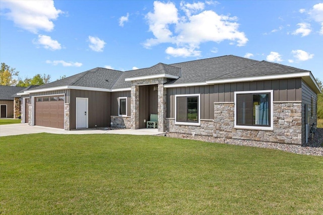 prairie-style house with board and batten siding, concrete driveway, roof with shingles, a front yard, and an attached garage