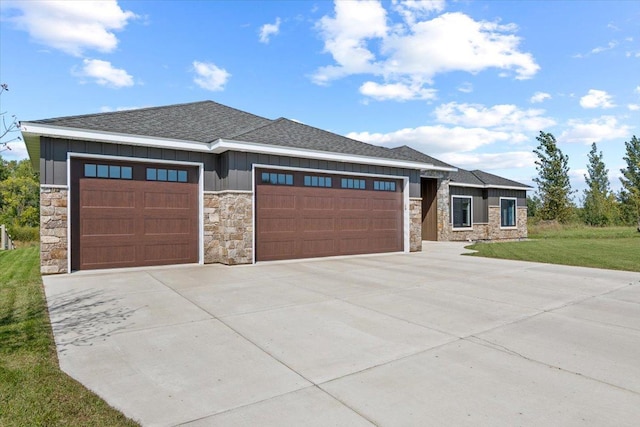 prairie-style house with roof with shingles, an attached garage, concrete driveway, a front lawn, and board and batten siding