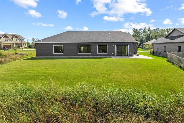 rear view of property featuring a patio and a yard