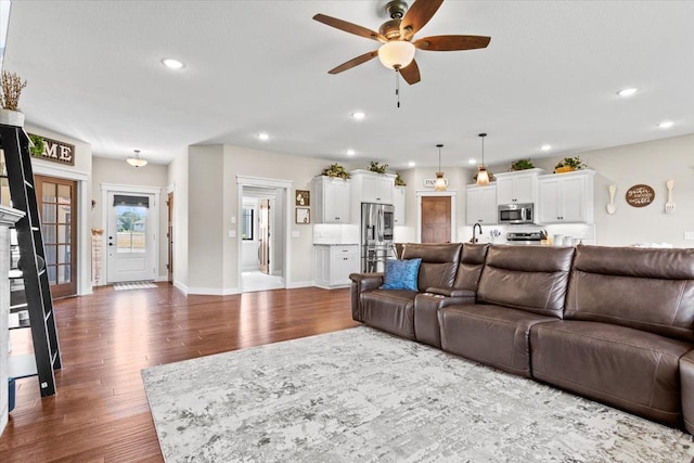 living room with a ceiling fan, recessed lighting, dark wood-style flooring, and baseboards