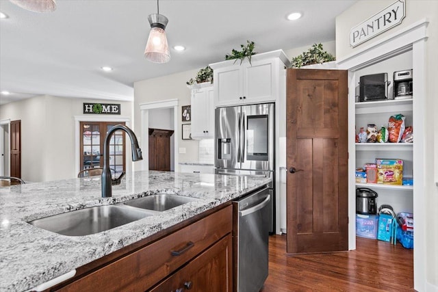 kitchen featuring dark wood-type flooring, a sink, light stone counters, white cabinetry, and stainless steel appliances