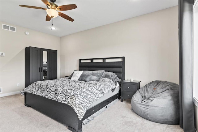 bedroom with visible vents, light carpet, baseboards, and a ceiling fan