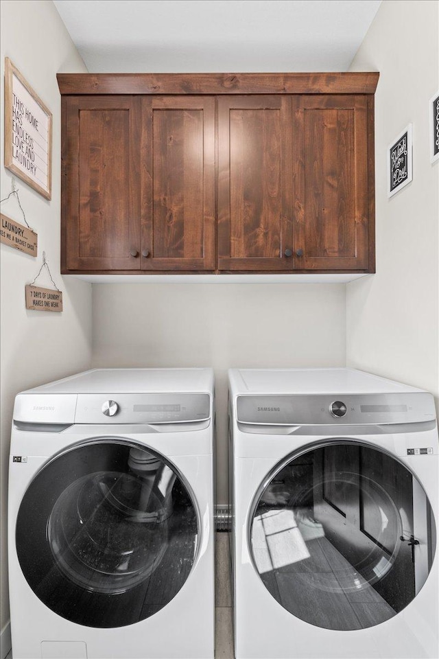 laundry room featuring washing machine and dryer and cabinet space