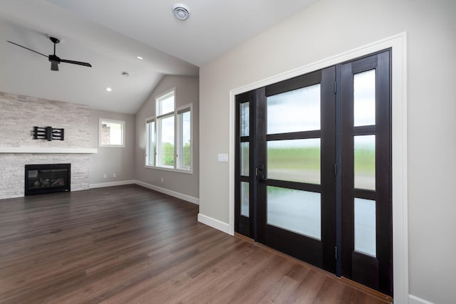 foyer featuring a fireplace, vaulted ceiling, dark hardwood / wood-style floors, and ceiling fan