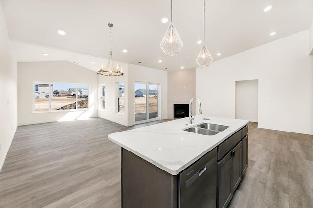 kitchen with an island with sink, sink, and light wood-type flooring