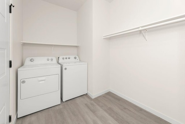 laundry room with light hardwood / wood-style flooring and independent washer and dryer