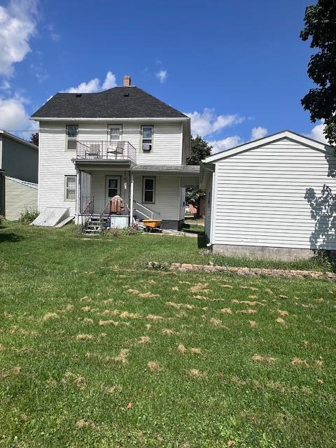 back of house featuring a lawn