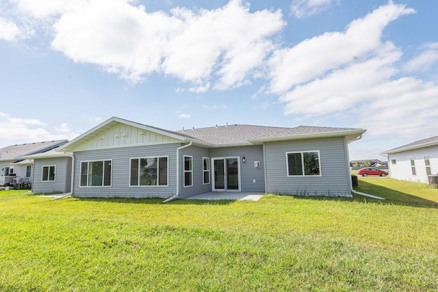 rear view of property with a lawn and a patio