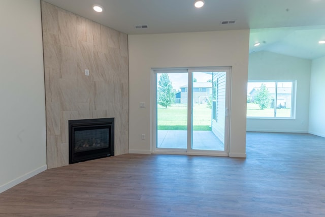 unfurnished living room featuring hardwood / wood-style flooring, a fireplace, and vaulted ceiling