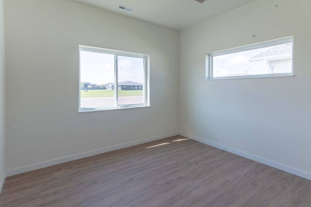 empty room with hardwood / wood-style floors and a wealth of natural light