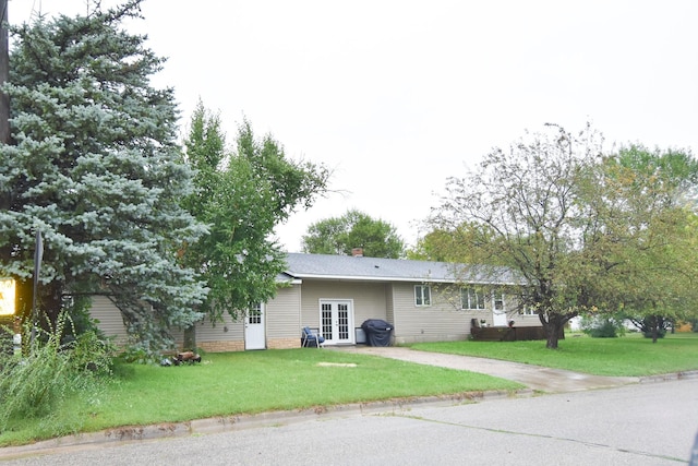 102 6th St SW, Red Lake Falls, MN 56750 - back of property featuring french doors, driveway, a yard, and a chimney