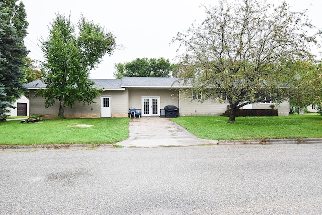 102 6th St SW, Red Lake Falls, MN 56750 - ranch-style house with french doors, a front yard, driveway, and roof with shingles
