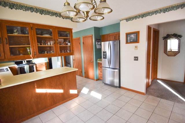 102 6th St SW, Red Lake Falls, MN 56750 - kitchen with stainless steel appliances, light tile patterned flooring, a chandelier, and glass insert cabinets